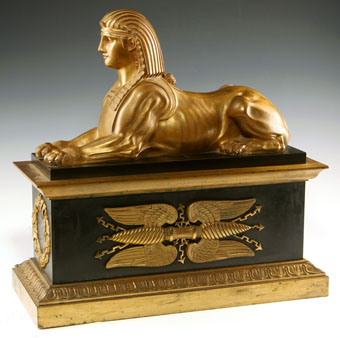 pair of gilt and paginated bronze chenets with sphinx