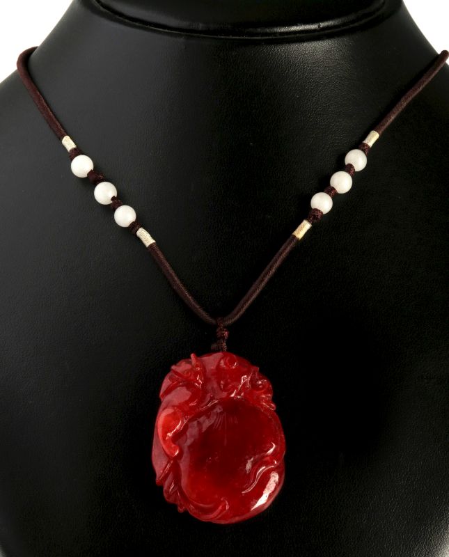 A CARVED RED JADE PENDANT