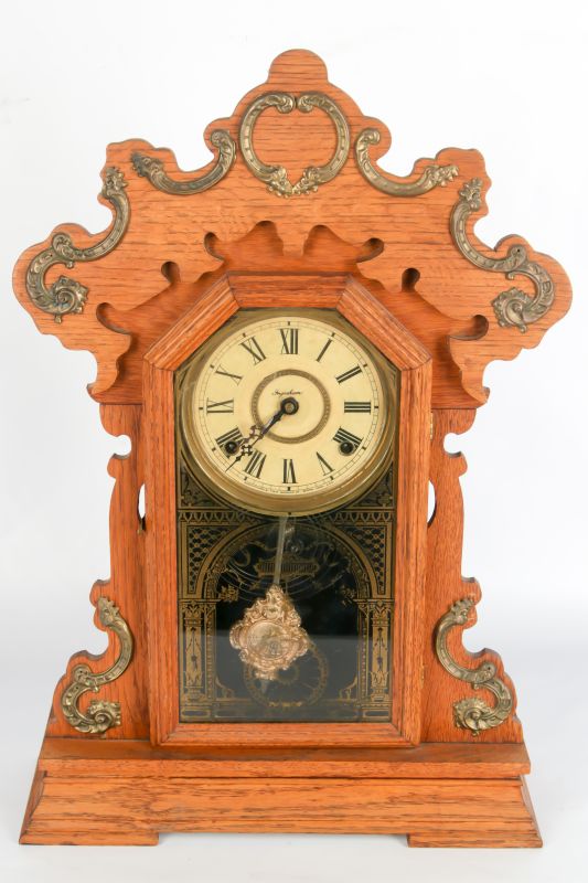 AN INGRAHAM KITCHEN CLOCK WITH BRASS ORNAMENTs