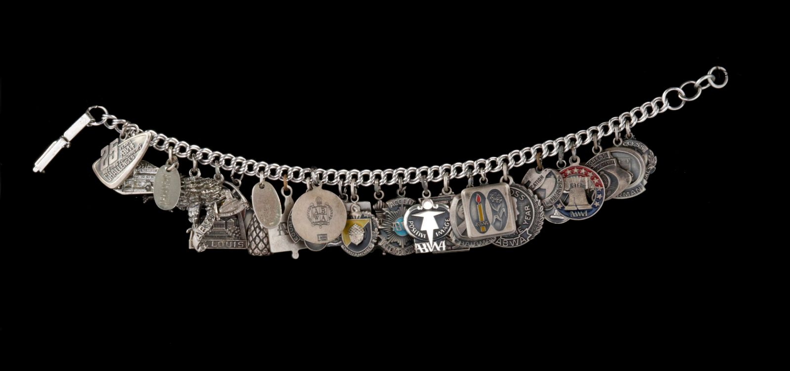 AN ABWA AWARDS BRACELET WITH 25 STERLING CHARMS