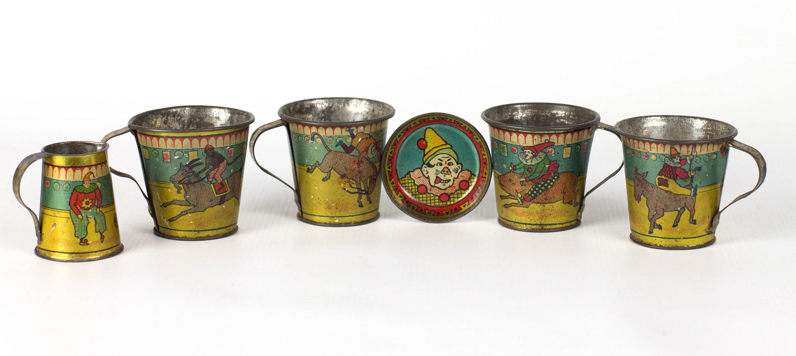 A SET OF CHILD'S TEA CUPS WITH CIRCUS CLOWNS