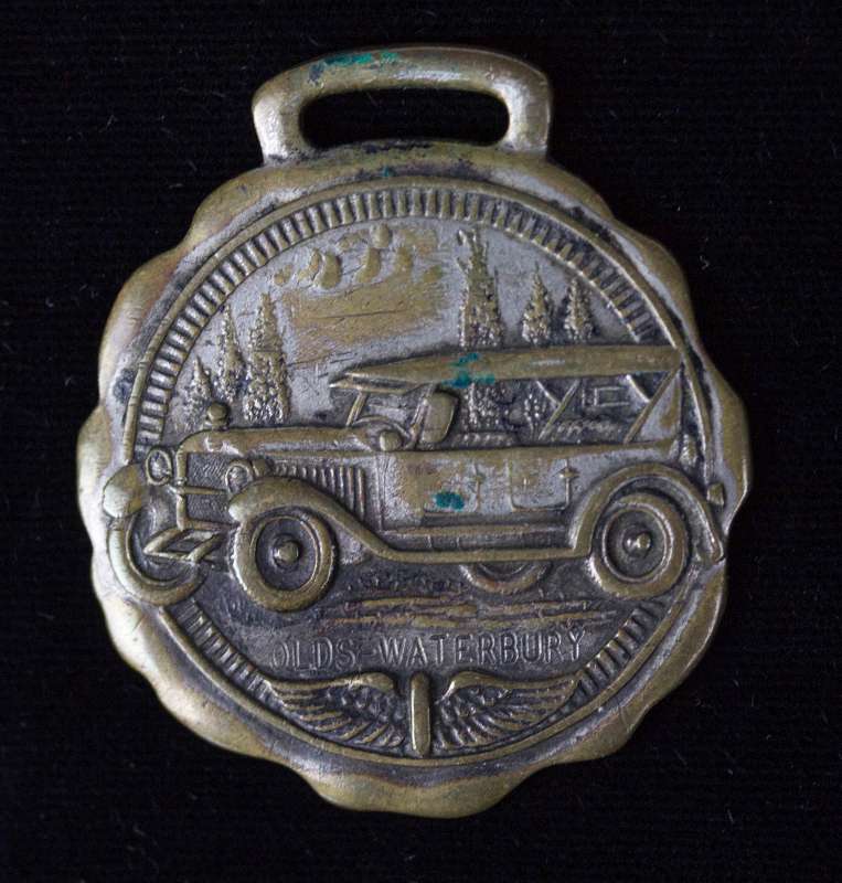 A RARE OLDS-WATERBURY AUTOMOBILE ADVERTISING FOB
