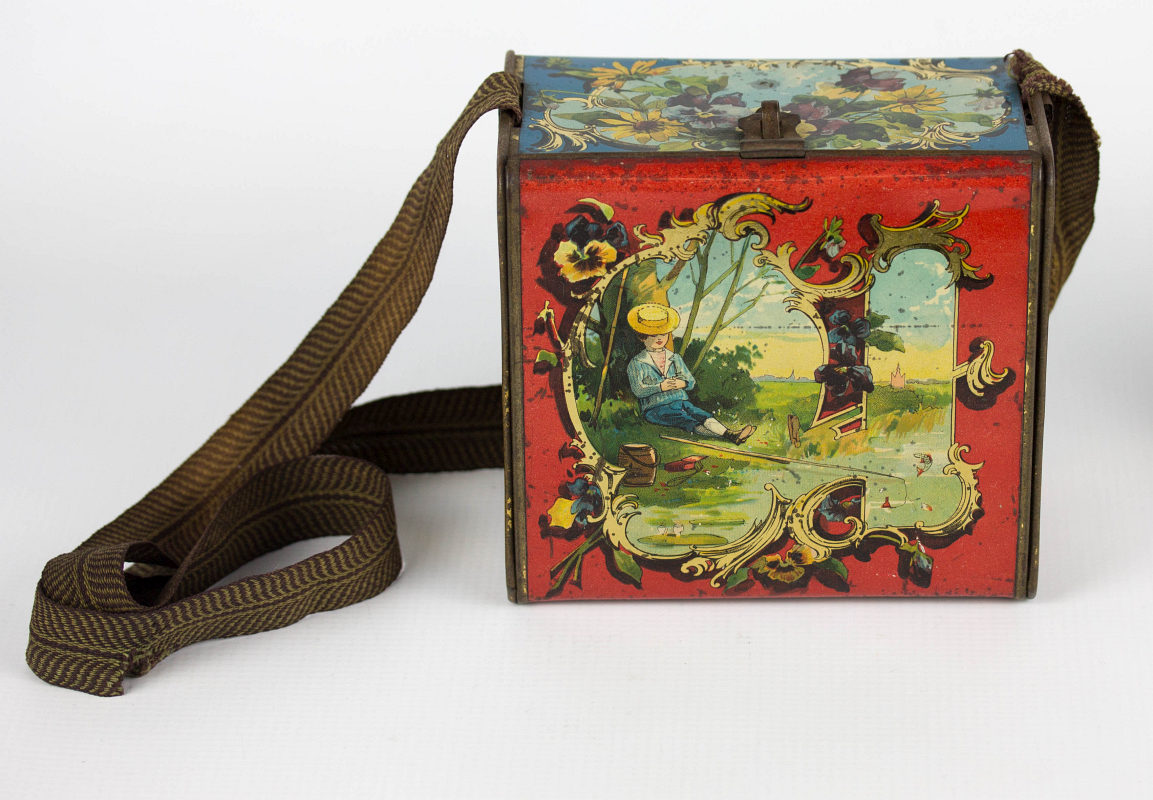 A LITHOGRAPHED LUNCH TIN WITH STRAP