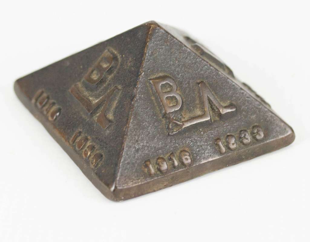 A PYRAMID FORM BRONZE ADVERTISING PAPERWEIGHT