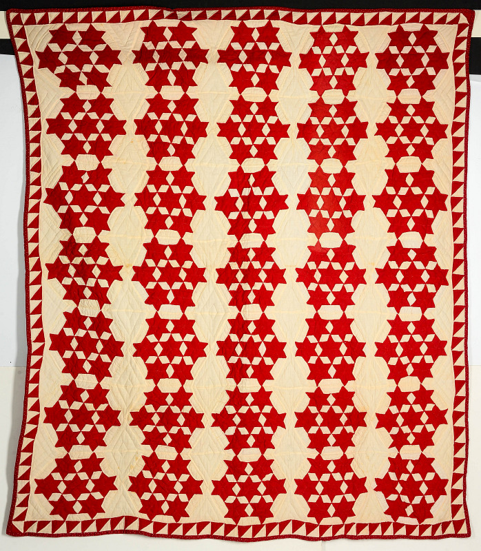 AN ANTIQUE RED AND WHITE STAR QUILT