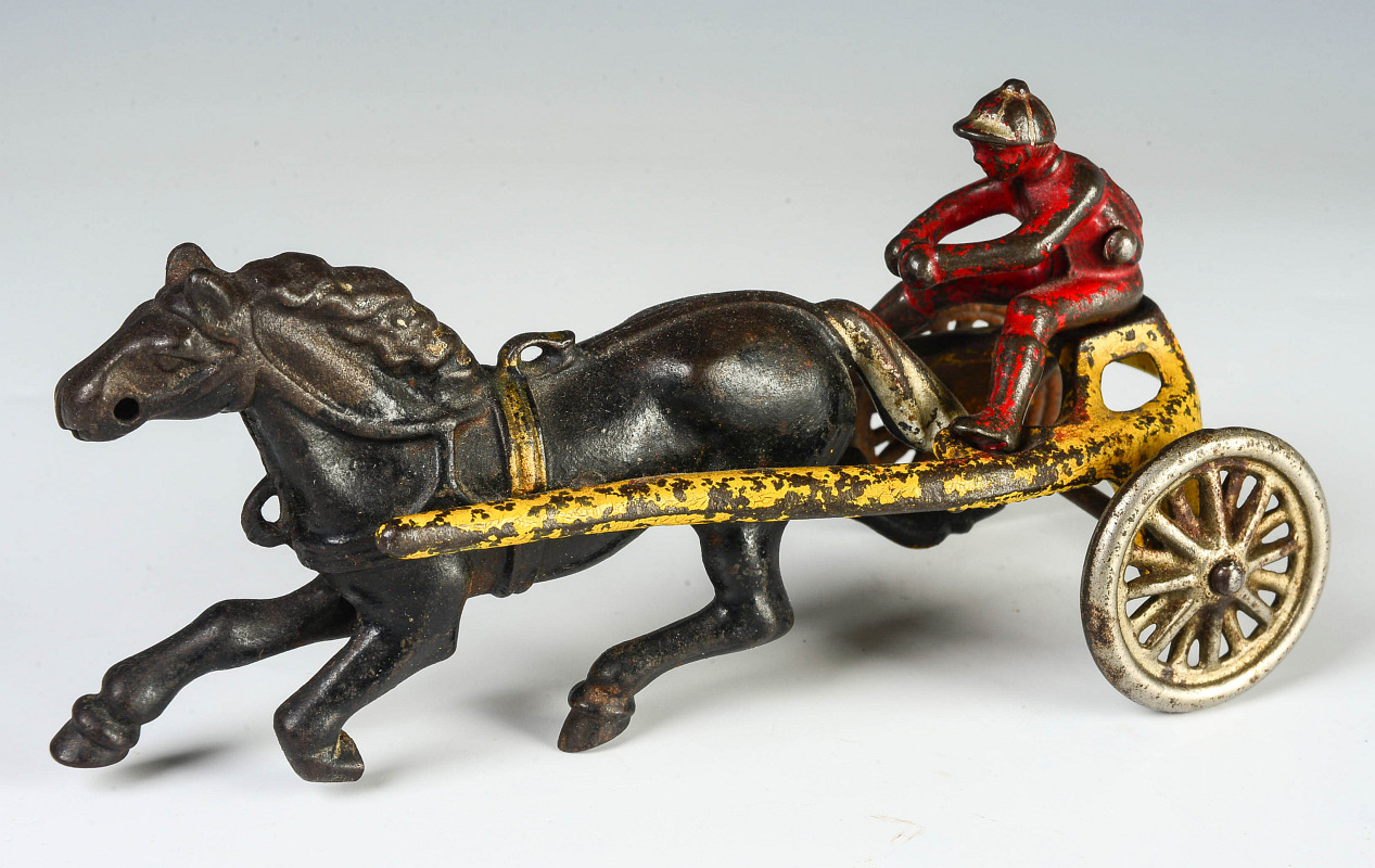 A CIRCA 1920 CAST IRON HORSE HARNESS RACING TOY 