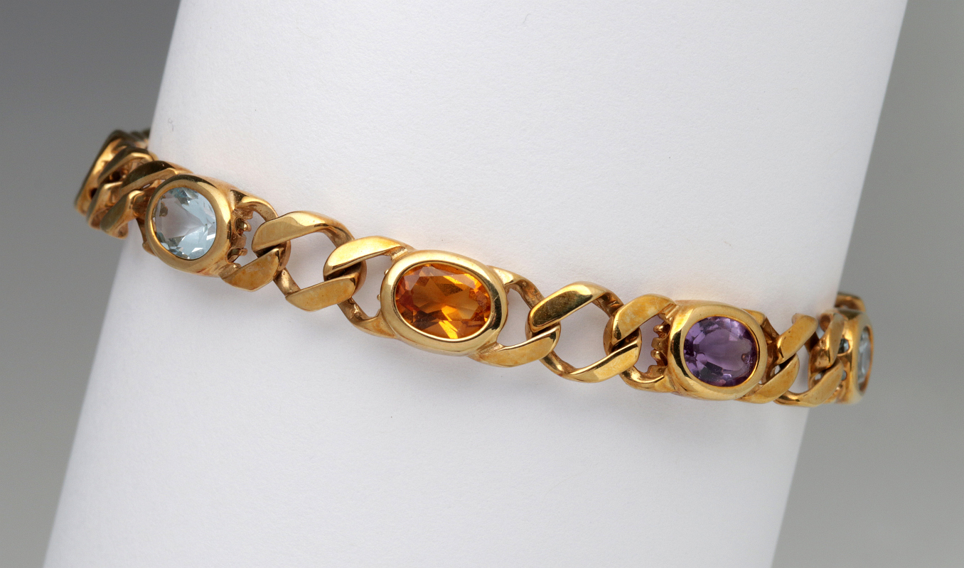 A 14K GOLD CURB LINK BRACELET WITH COLORED STONES