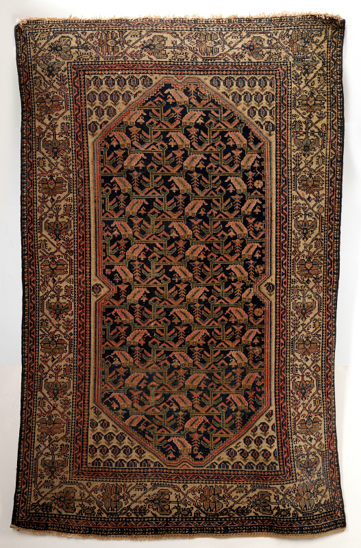 AN ANTIQUE PERSIAN RUG ATTRIBUTED AS SENNEH