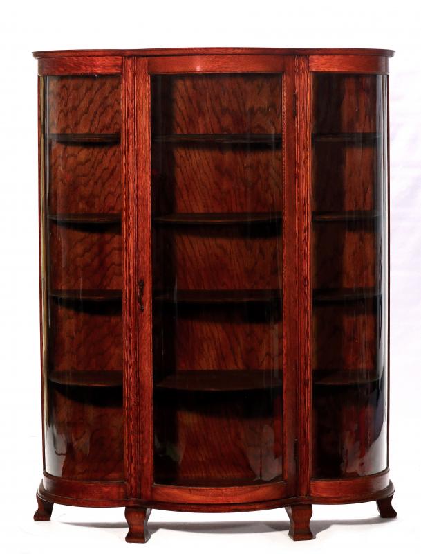 A CIRCA 1900 OAK CHINA CABINET WITH ROUNDED GLASS
