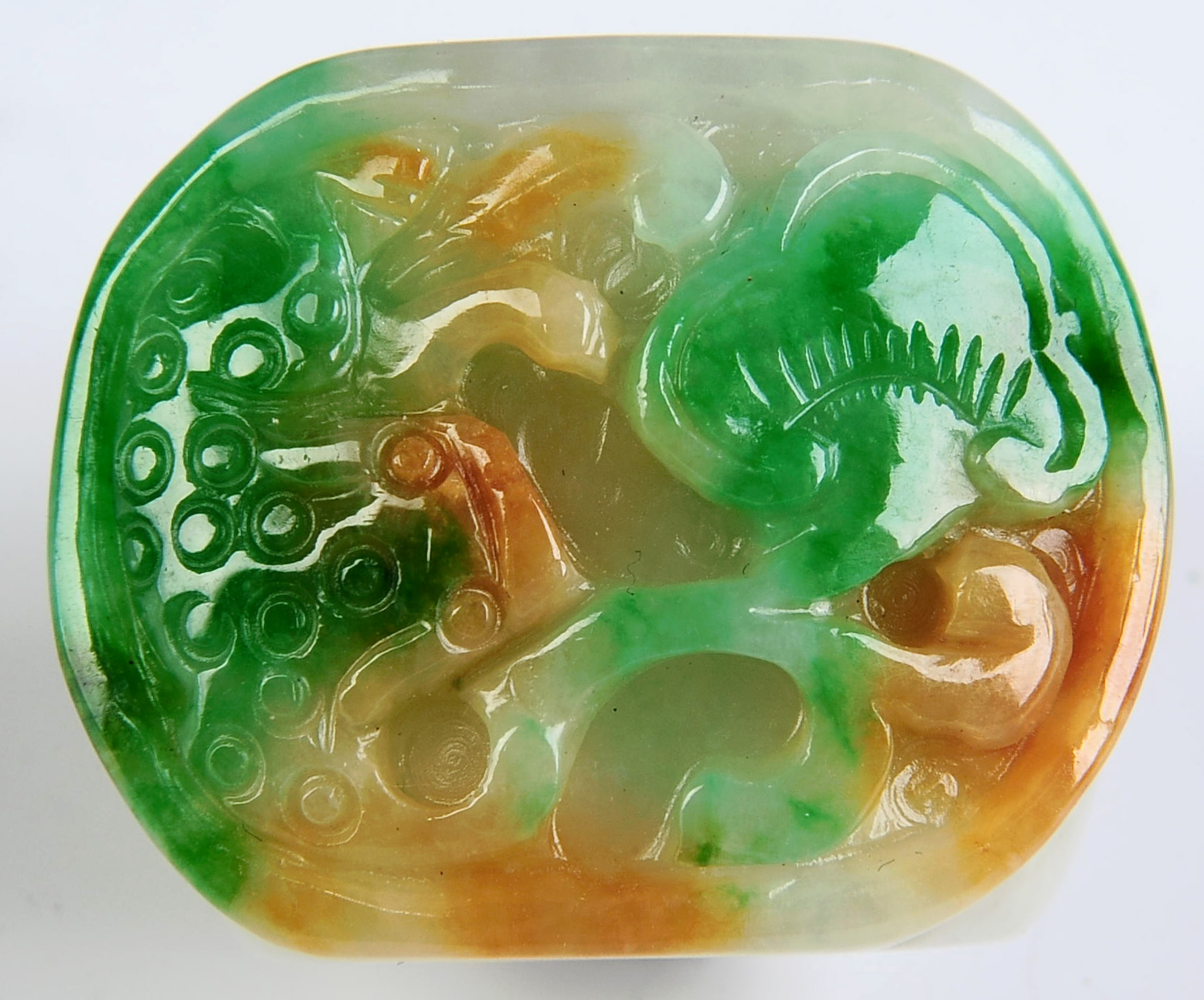 A CARVED THREE-COLOR JADE THUMB RING