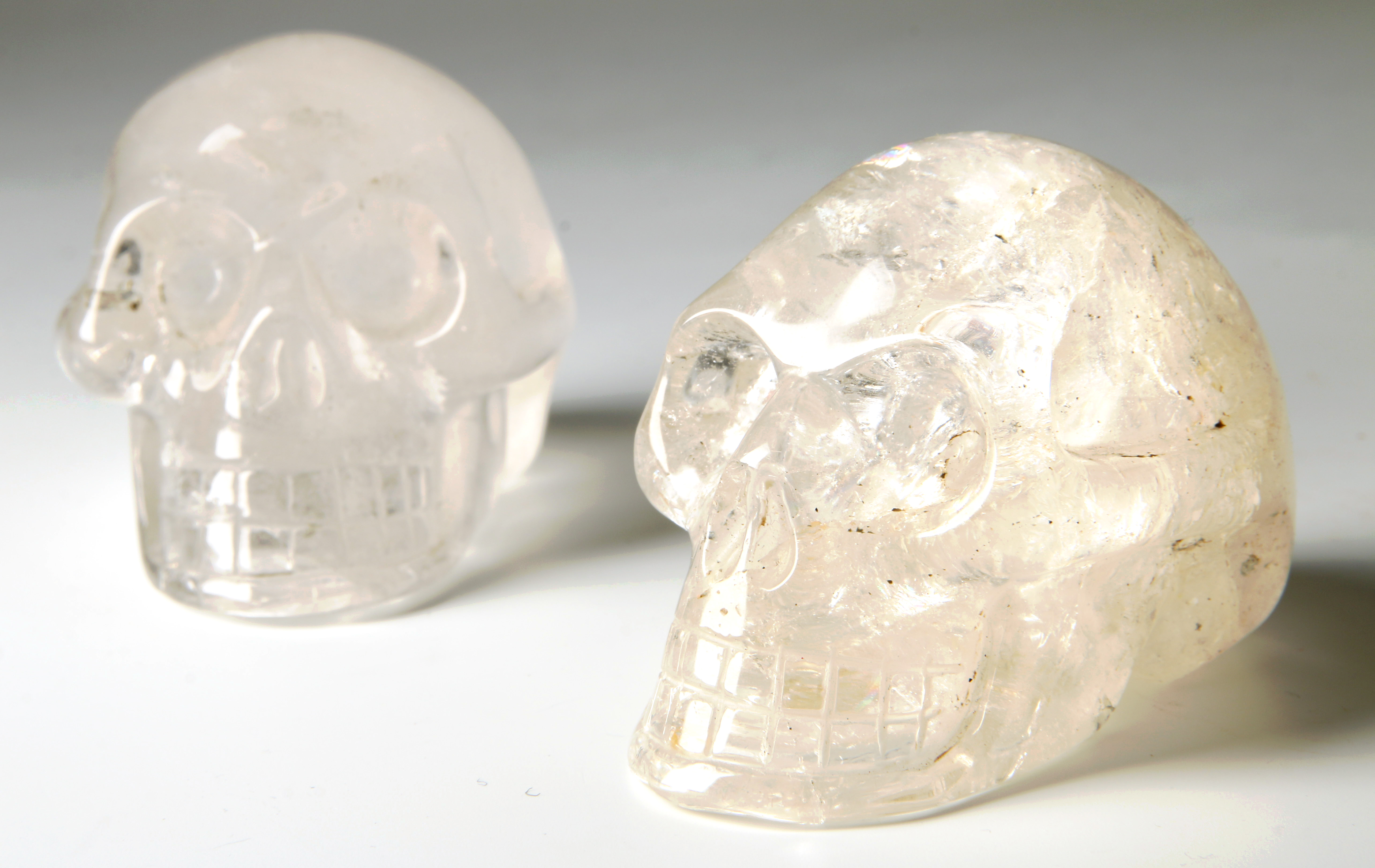TWO ROCK CRYSTAL SKULL FORM CARVINGS