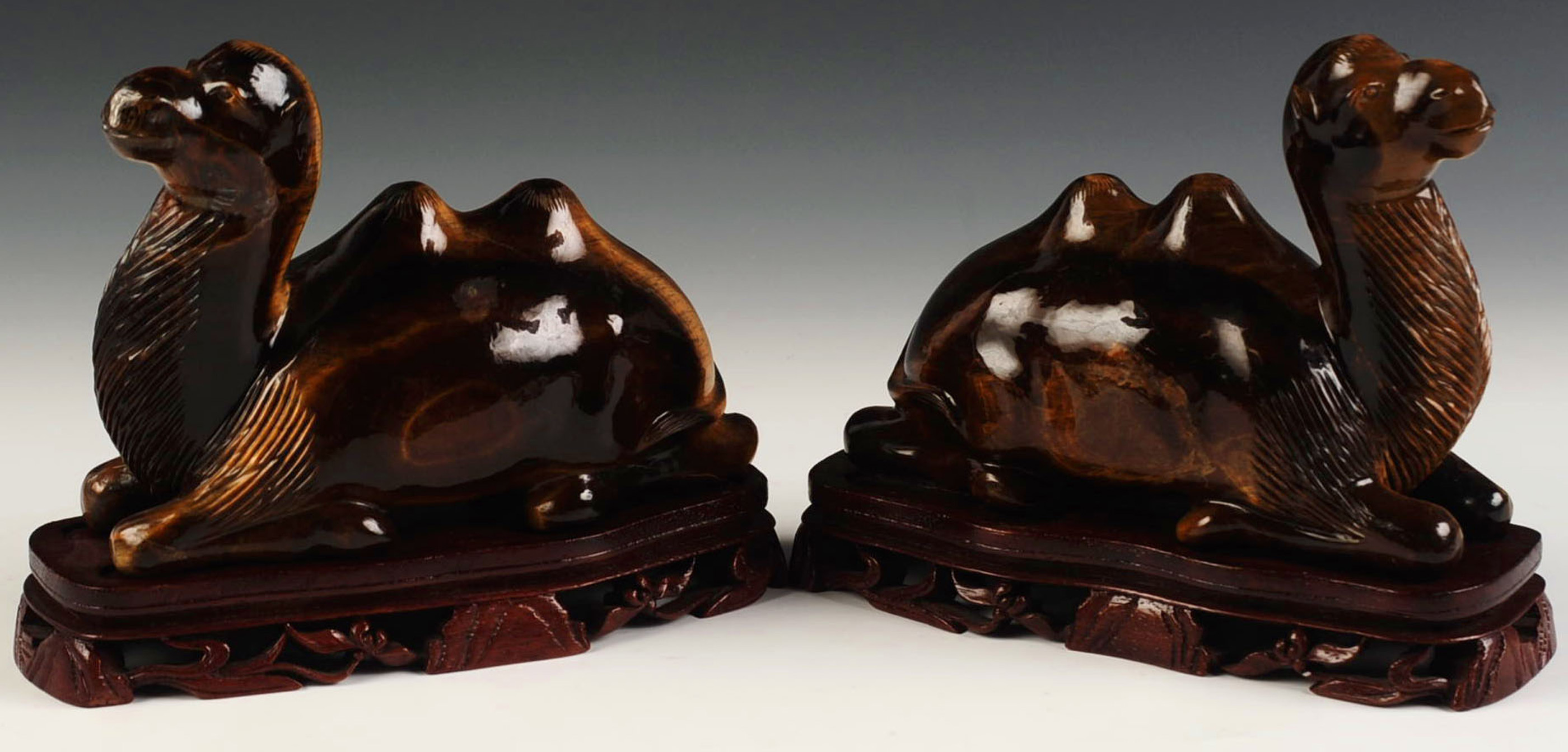 A PAIR OF CHINESE TIGER EYE CARVED CAMEL FIGURES