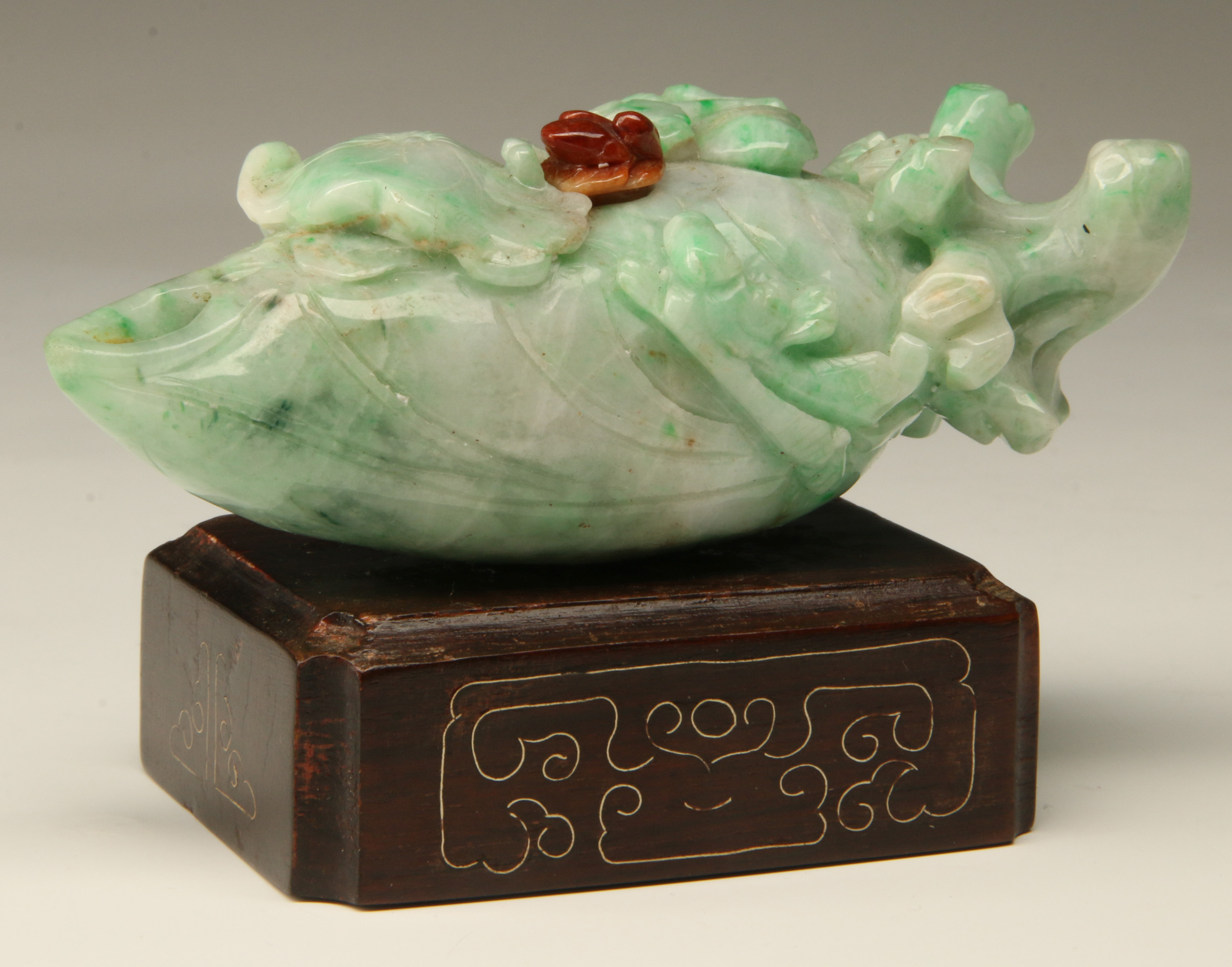 A CHINESE CARVED JADEITE FRUIT WITH AGATE BUD