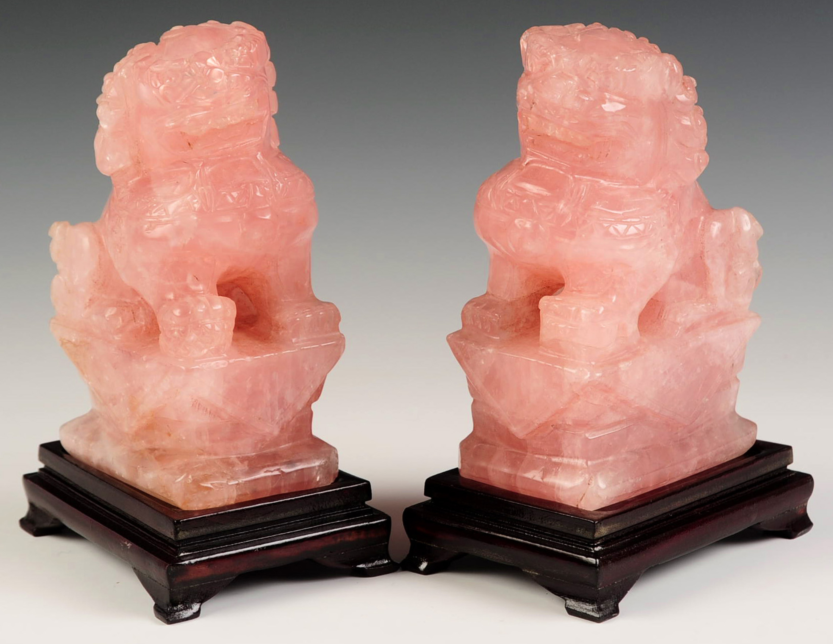 A PAIR OF CHINESE FU DOG ROSE QUARTZ CARVINGS