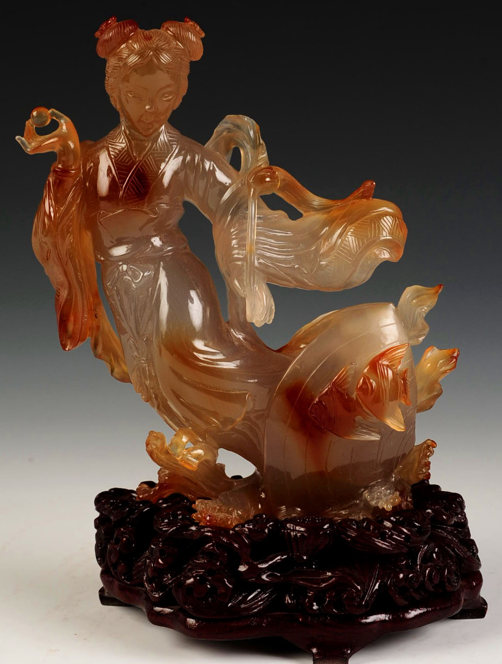 A CHINESE AGATE CARVING ON FITTED HARDWOOD BASE
