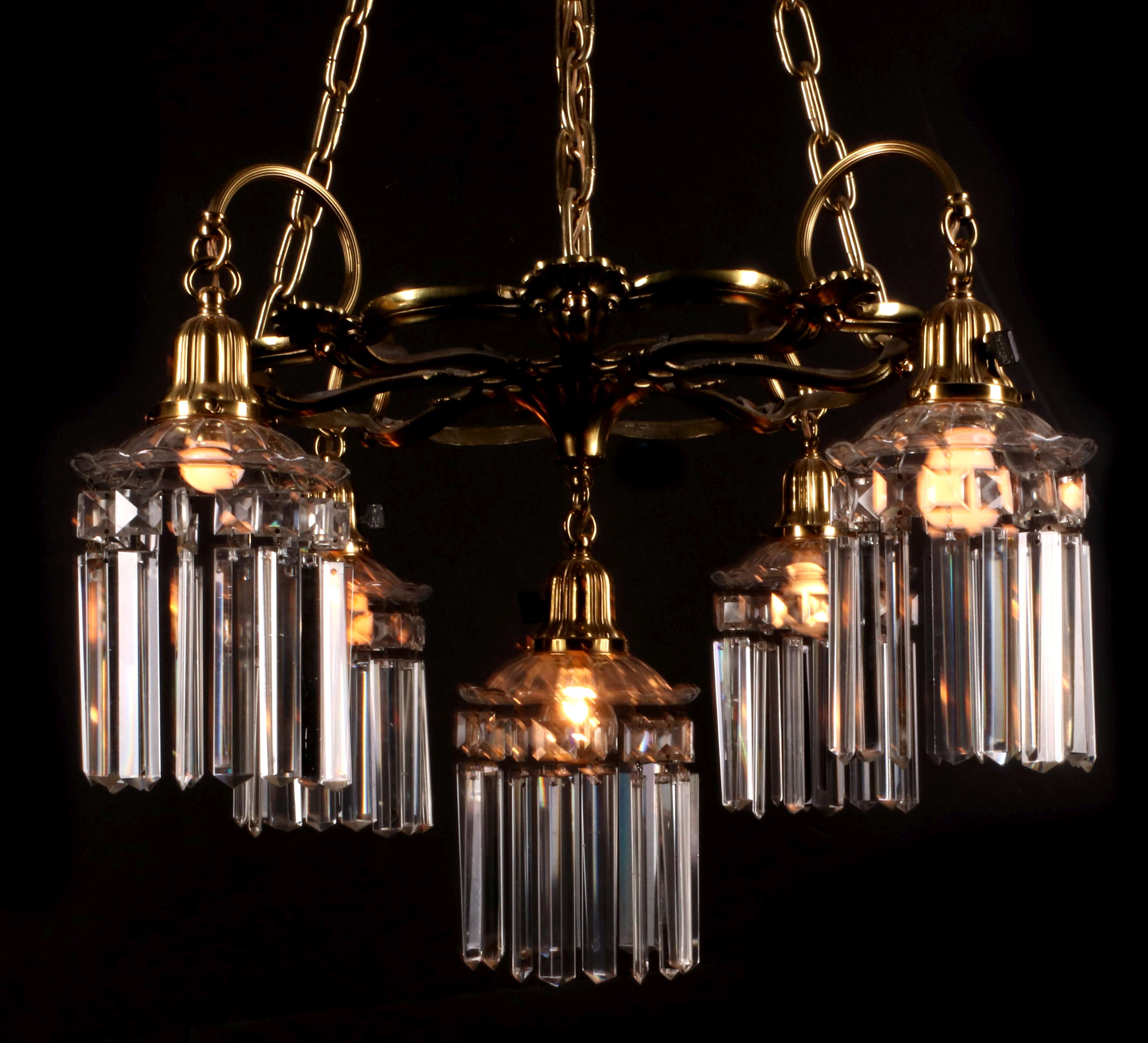 AN EARLY 20TH C BRASS CHANDELIER DRESSED IN PRISMS