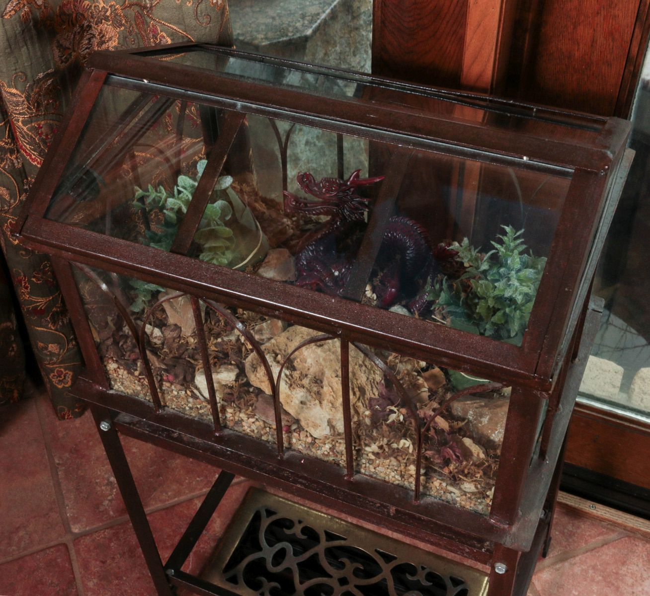 AN IRON AND GLASS TERRARIUM ON STAND