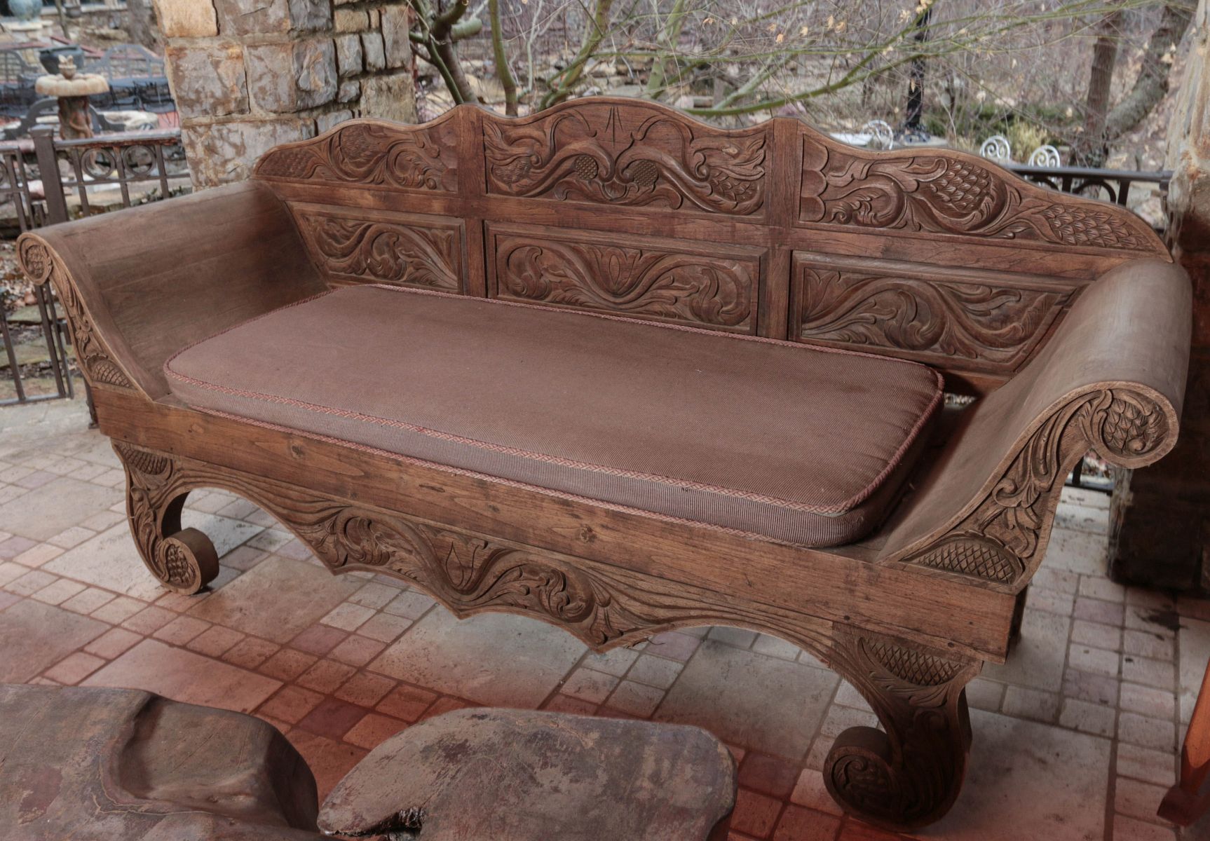AN ORNATE ASIAN TEAK WOOD BENCH CARVED OVERALL