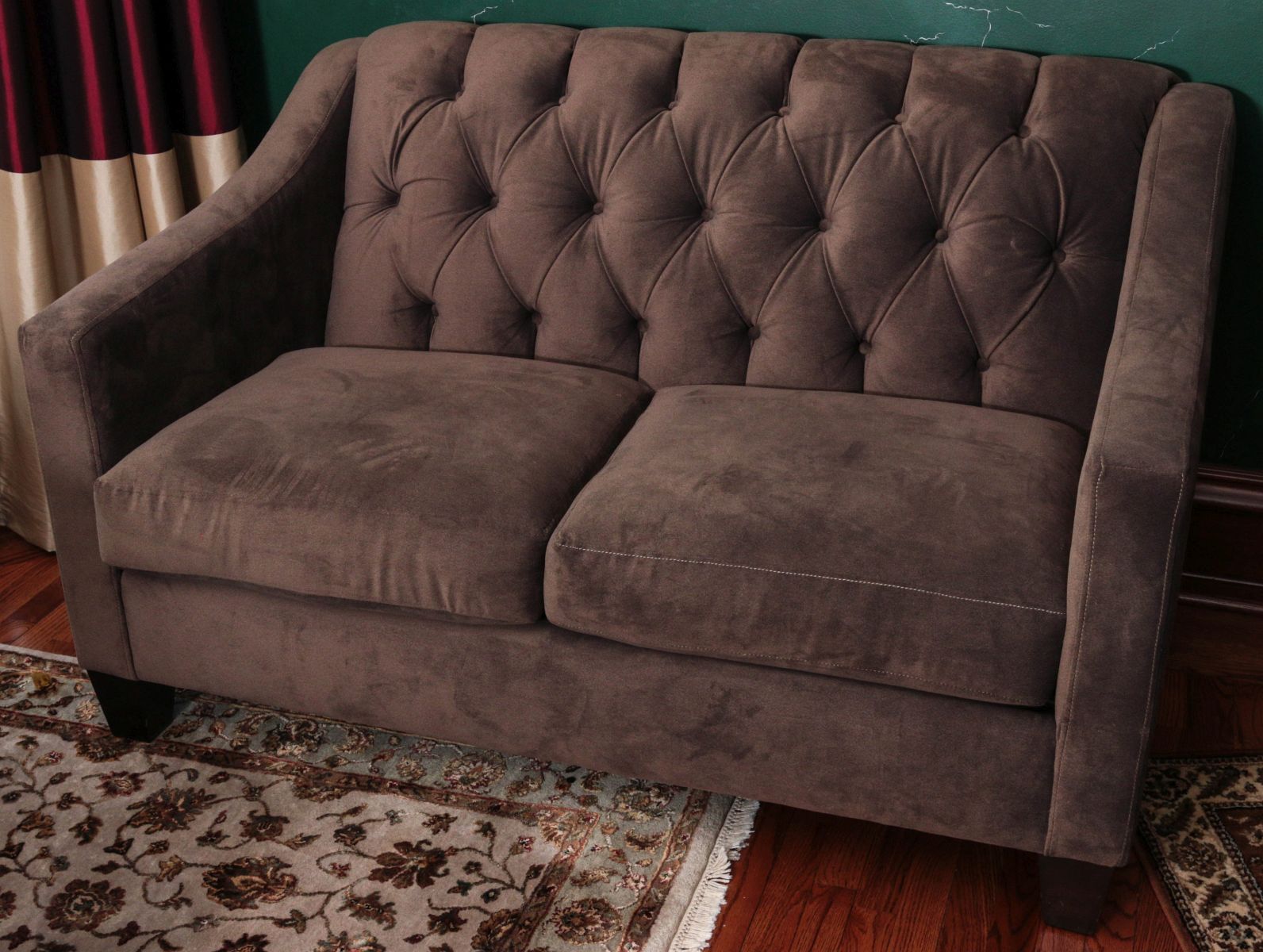 A TWO CUSHION LOVE SEAT WITH BUTTON TUCK BACK
