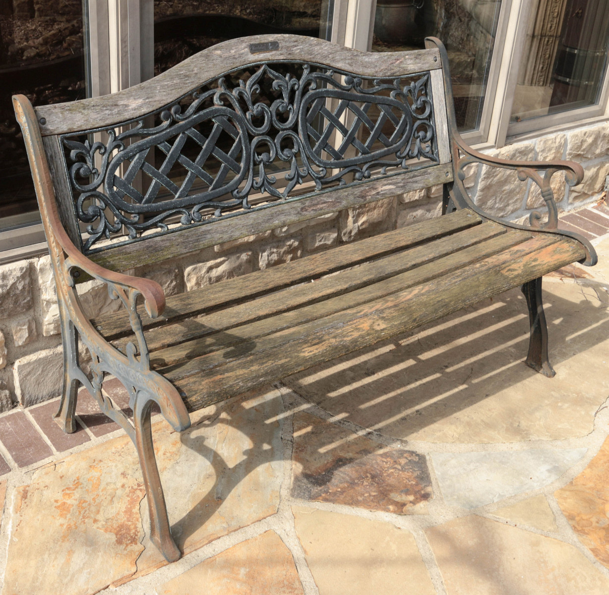 A CONTEMPORARY CAST IRON AND OAKWOOD SLAT BENCH