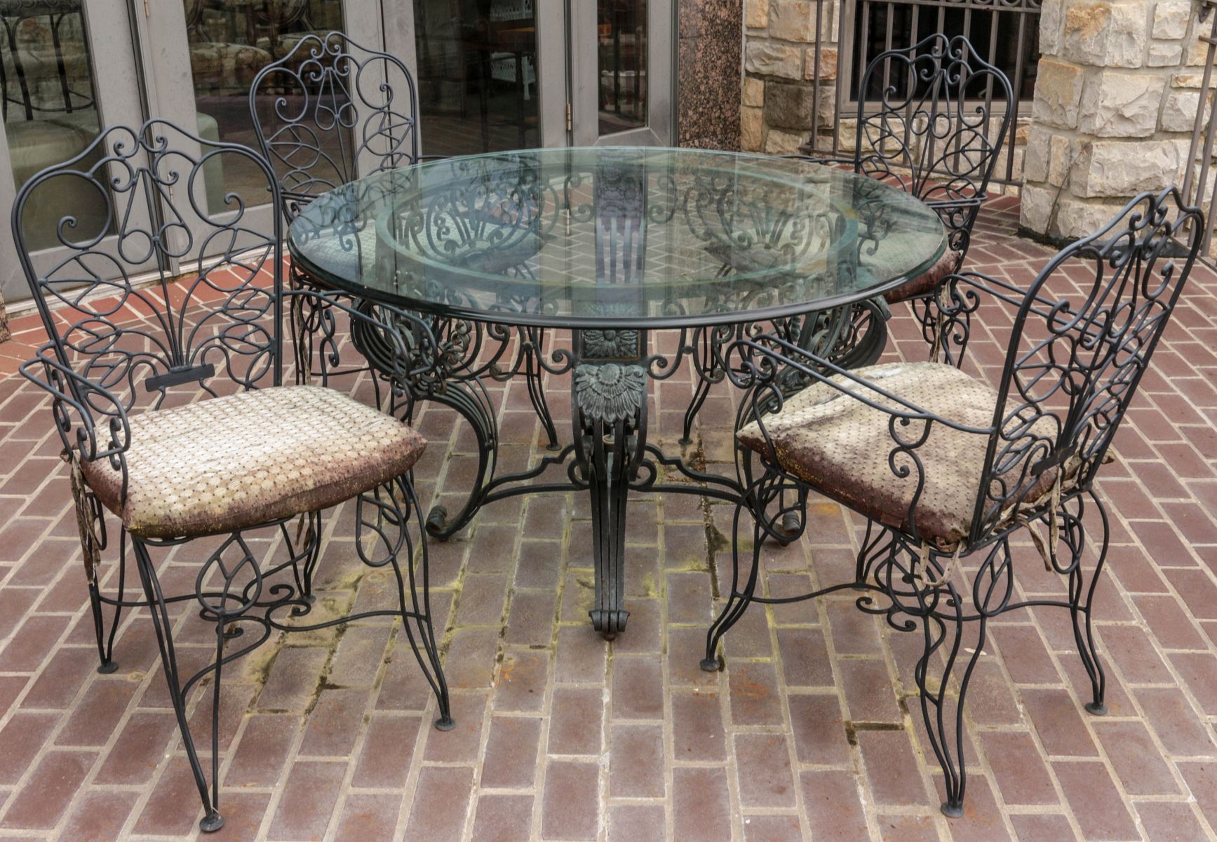 A SIX-CHAIR WROUGHT IRON OUTDOOR PATIO DINING SET