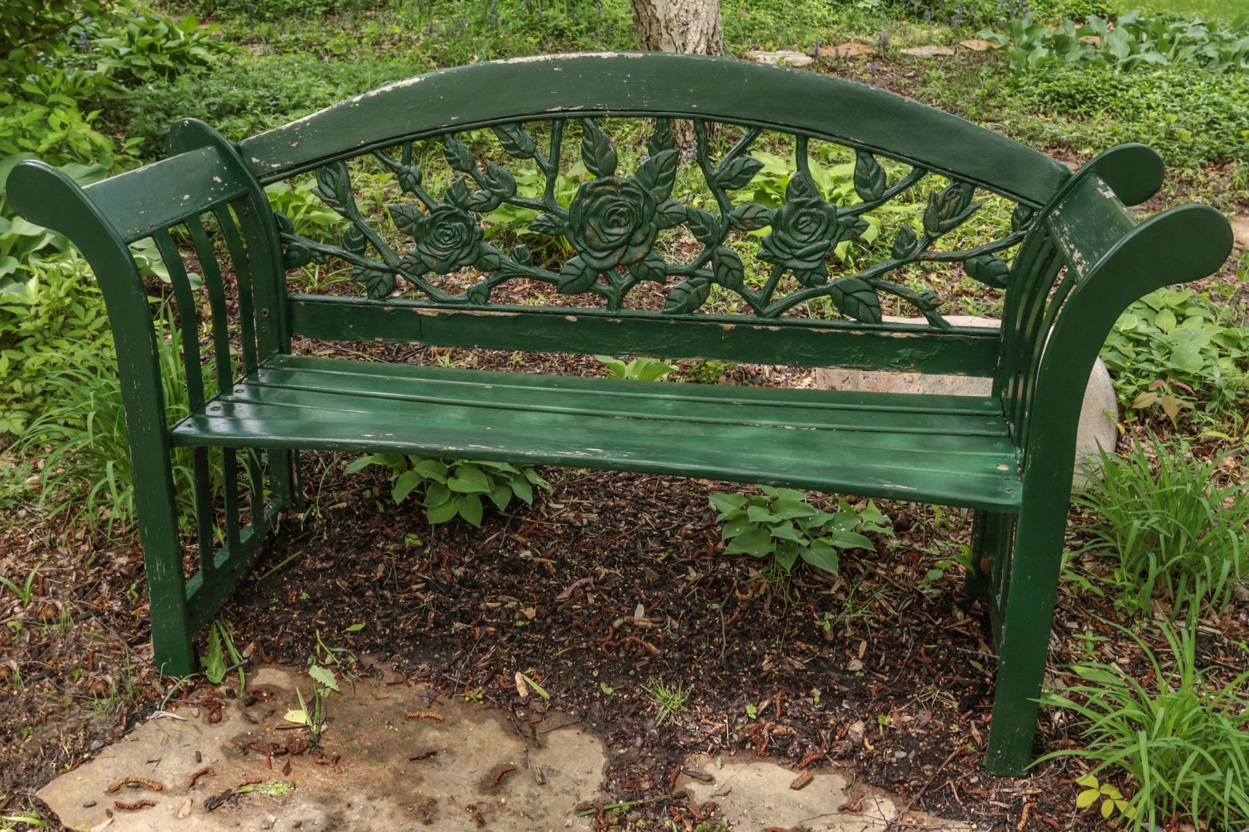 A WOOD GARDEN BENCH WITH OPENWORK CAST IRON BACK