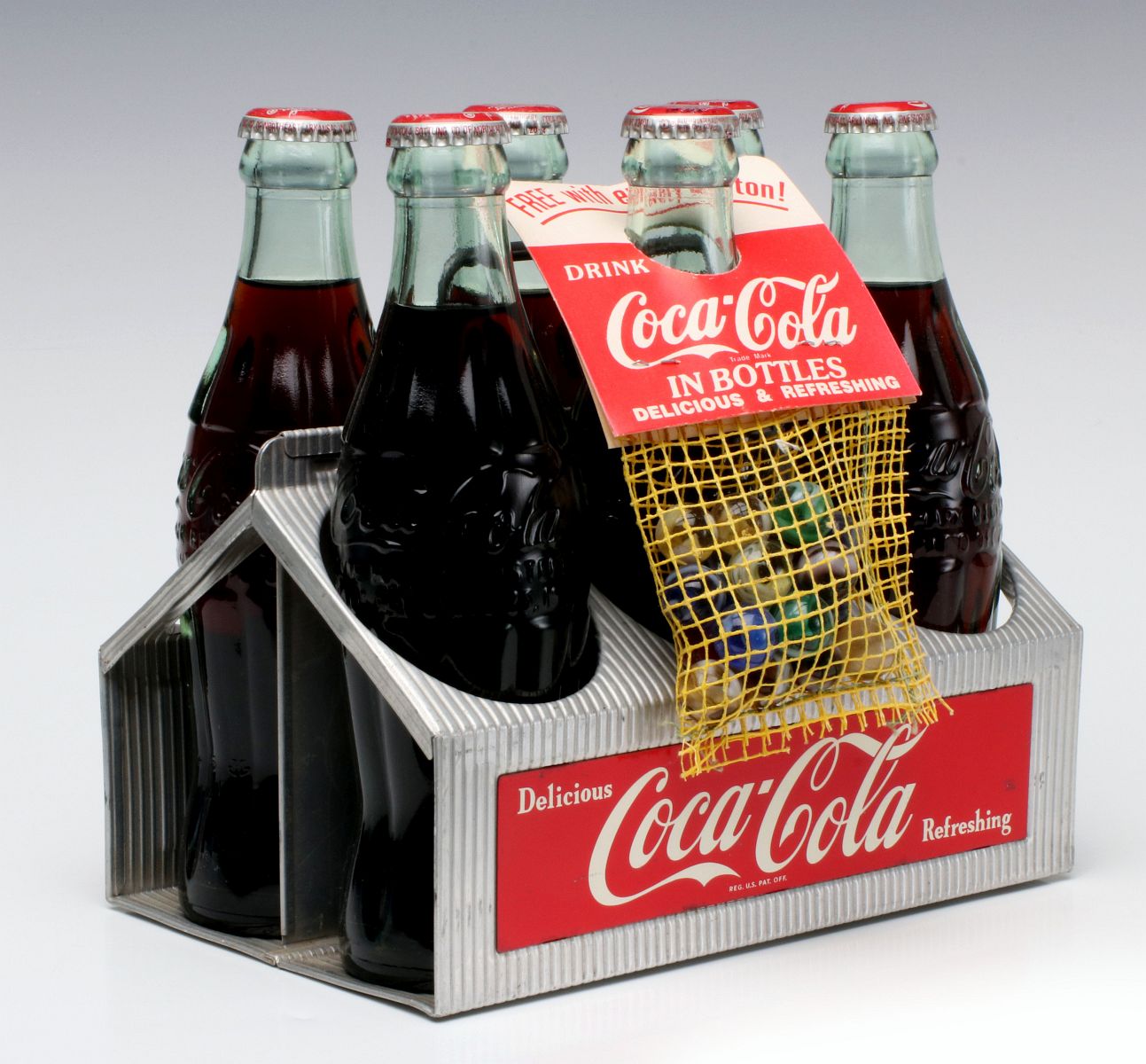 A 1950s COCA-COLA BOTTLE CARRIER WITH MARBLES PREMIUM