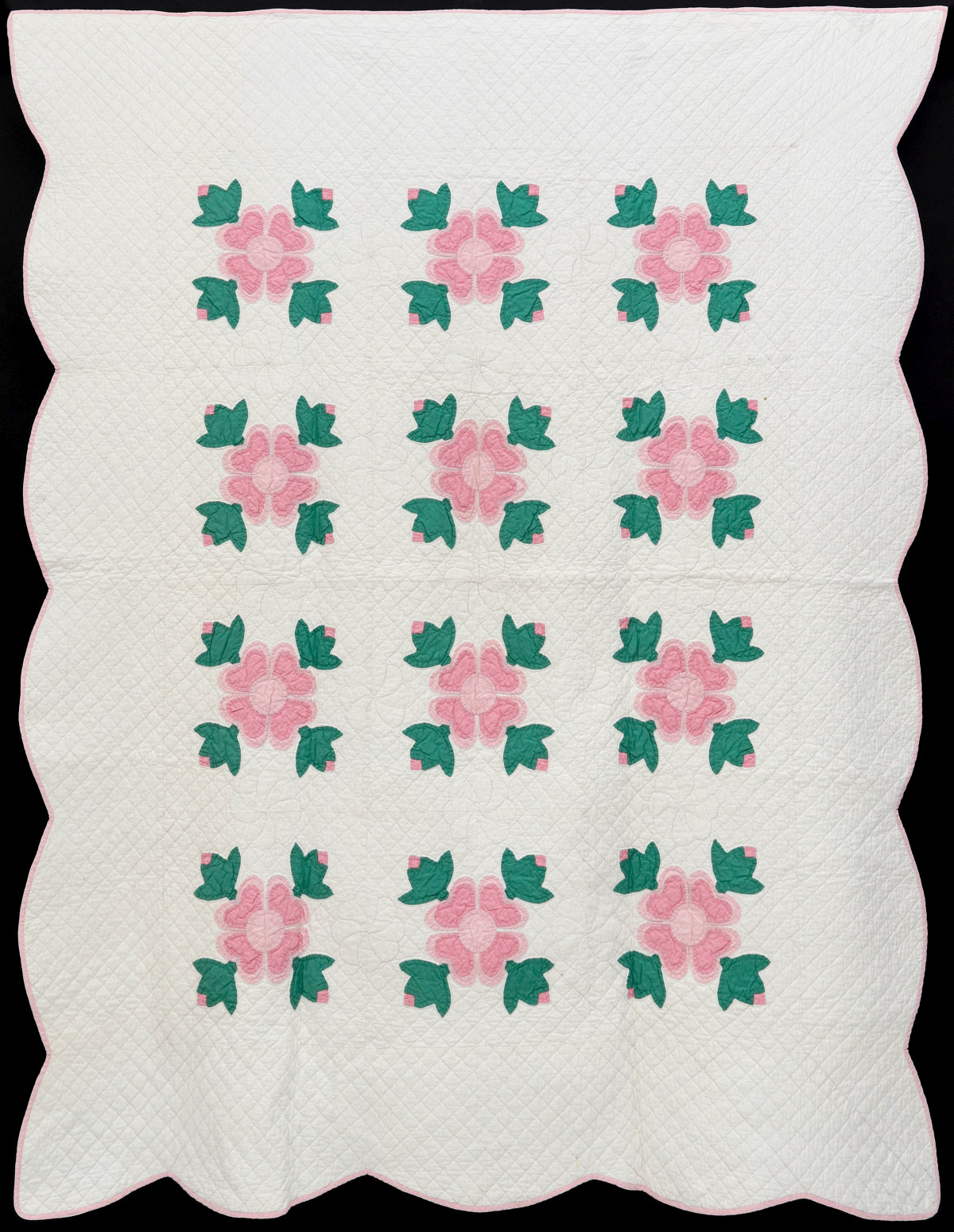 A NICE PINK AND GREEN APPLIQUE CROSSED TULIPS QUILT