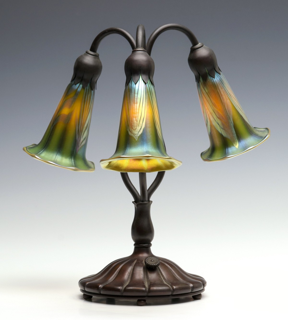 A BRONZE LILY LAMP WITH ORIENT AND FLUME SHADES