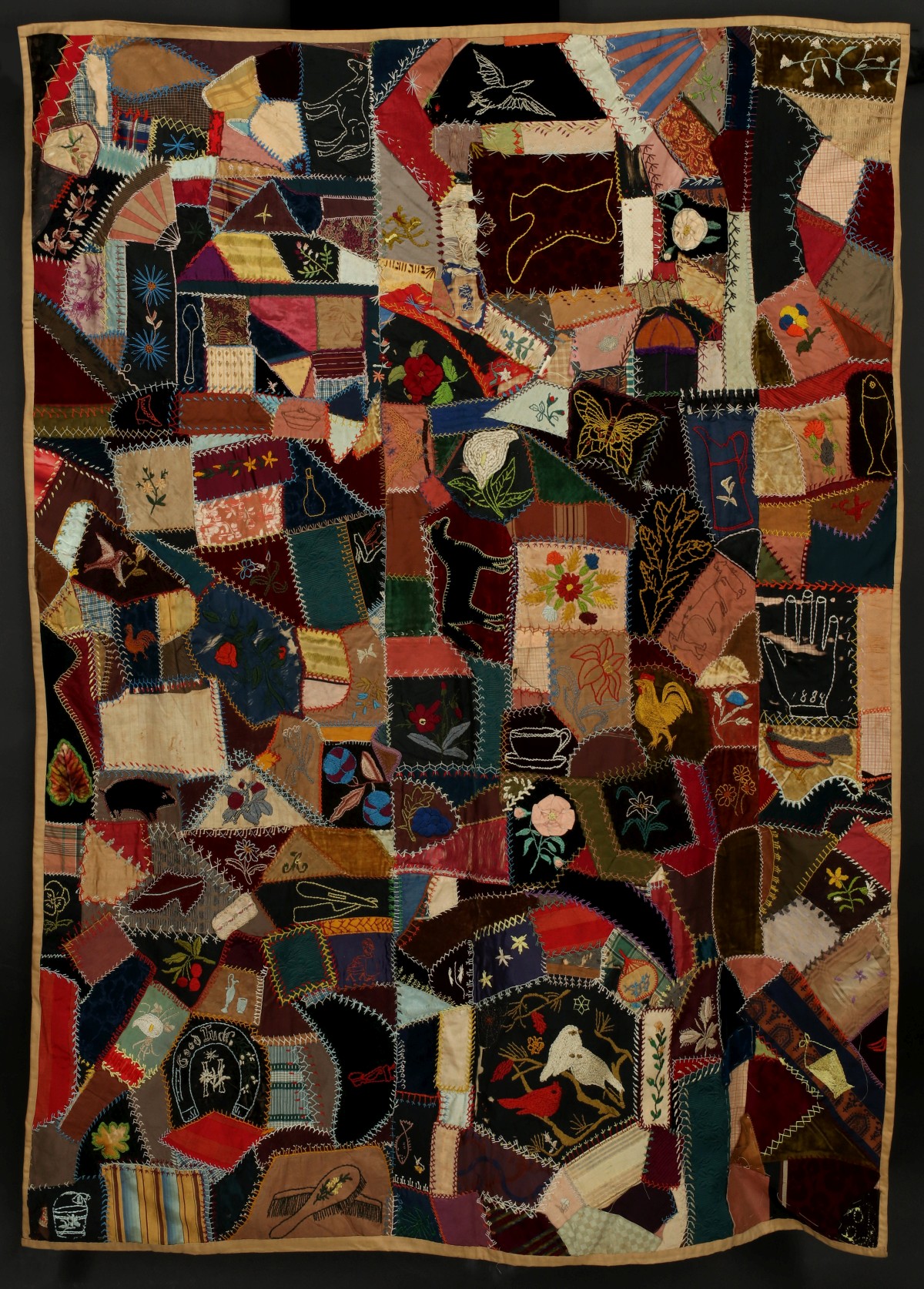 A ELABORATELY EMBROIDERED CRAZY QUILT DATED 1884