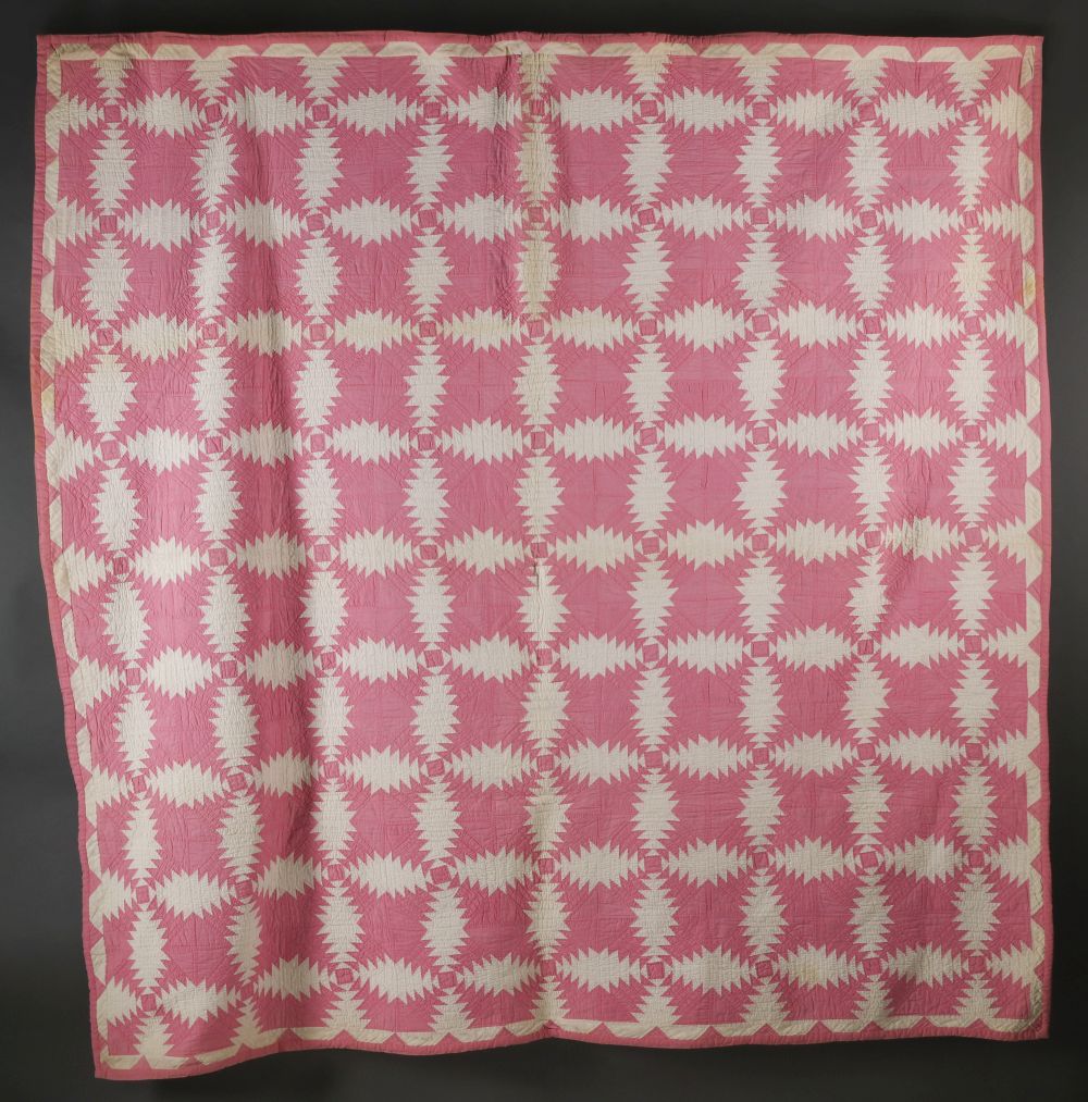 A VINTAGE PINK AND WHITE 'PINEAPPLE' PATTERN QUILT