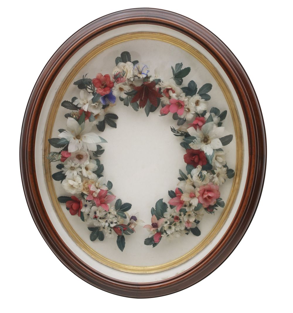 A VICTORIAN FEATHER WREATH IN OVAL WALNUT FRAME