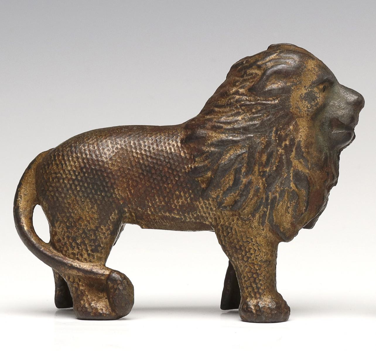 A RARE CAST IRON 'QUILTED' PATTERN LION STILL BANK