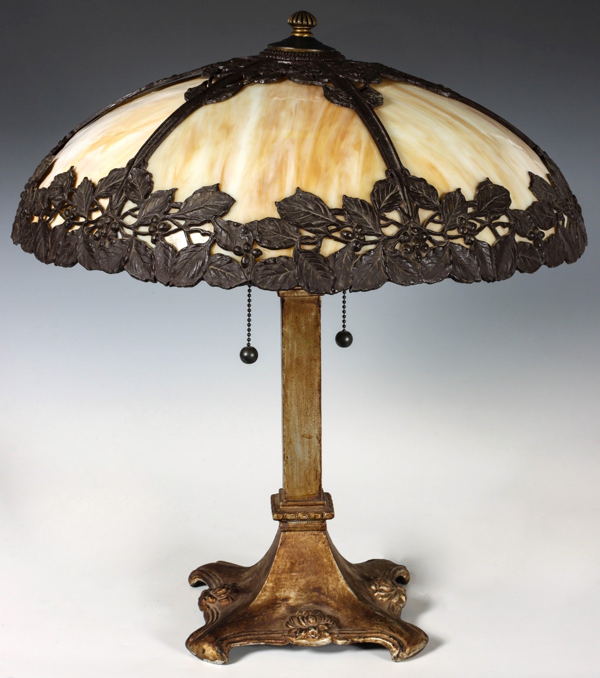 AN ORNATE FLORAL PATTERN LAMP WITH BENT GLASS PANELS