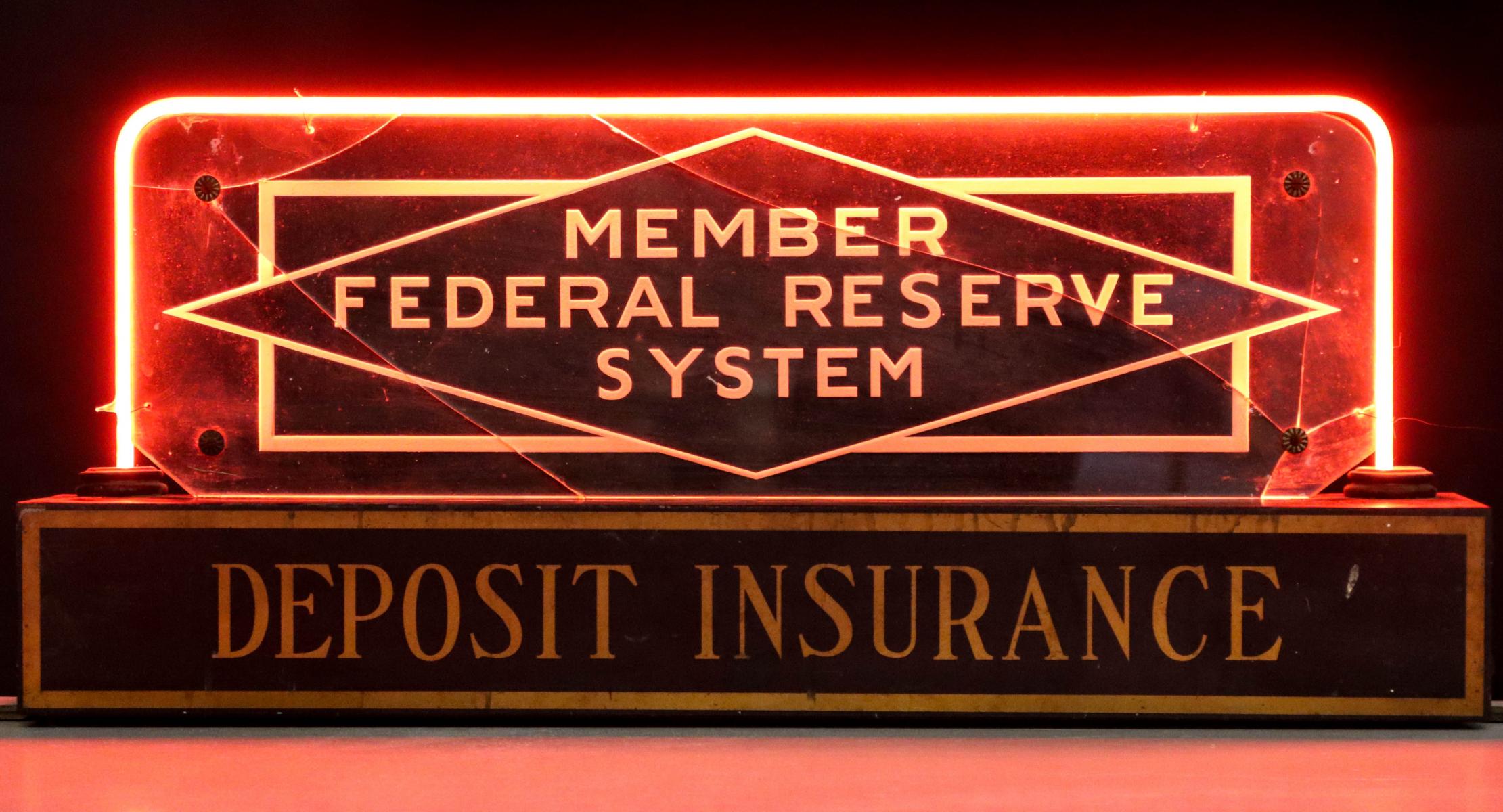 A FEDERAL RESERVE DEPOSIT INSURANCE SIGNED WITH RED NEON