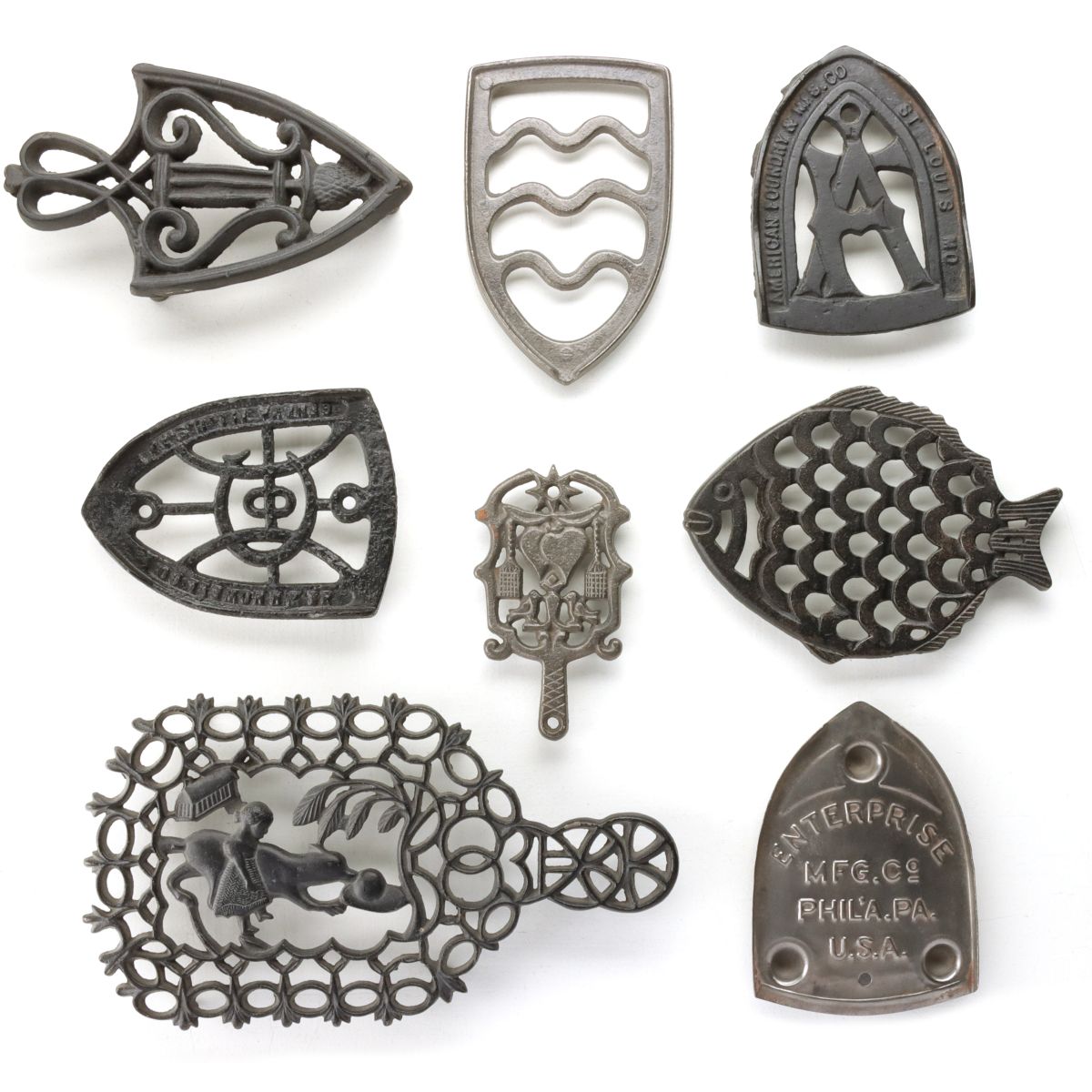 A COLLECTION OF FANCY PRESSING IRON TRIVETS