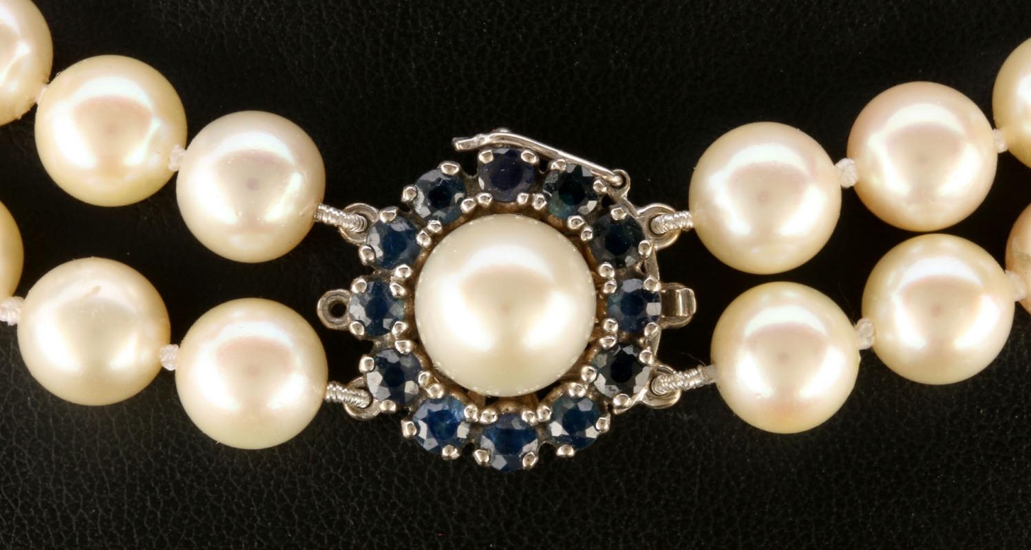 A CHOKER LENGTH PEARL STRAND WITH SAPPHIRE & GOLD CLASP