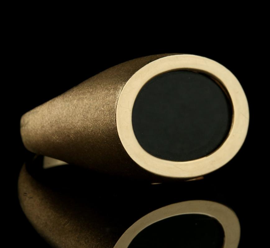 A GENT'S 10K GOLD AND ONYX FASHION RING