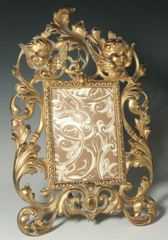 A ROCOCO STYLE BRONZE EASEL BACK FRAME WITH PUTTI