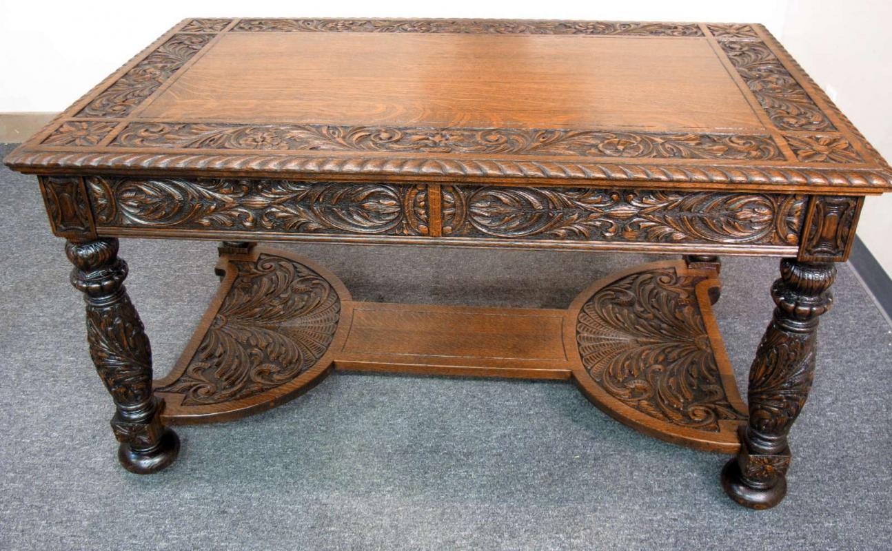 A HEAVILY CARVED OAK LIBRARY TABLE