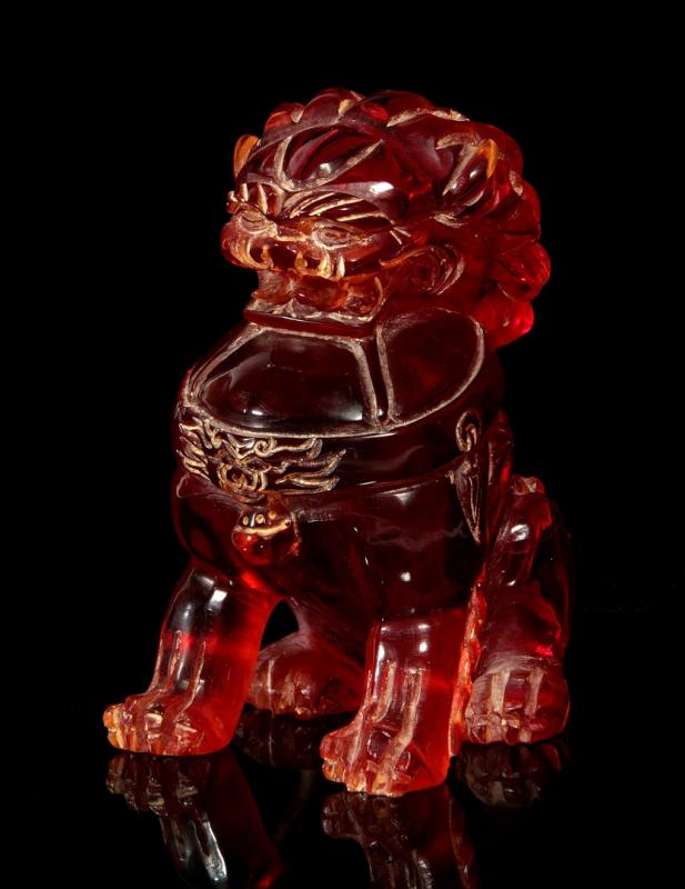 A 20TH C. CHINESE CHERRY AMBER FOOD DOG CARVING